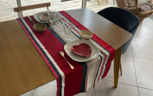 Chemin de table ARROZA en coton satiné rouge à rayures grises, roses et noire sur une table dressée